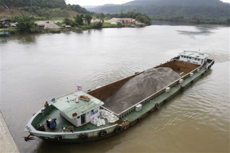 In this Aug. 2, 2011 photo, a Vietnamese vessel hauling sand plies the Tatai River in southwestern Cambodia. 